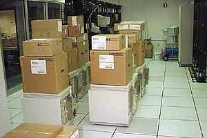 Stacks of HP and Compaq shipping boxes staged on a raised data-center floor
