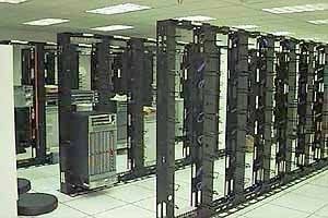 Rows of black open-frame server racks on a raised floor in the 1997 St. Louis data center