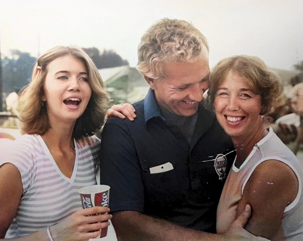 Monty Roberts in a Busch crew shirt laughing with family at an outdoor event